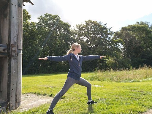 eine Frau macht eine Yoga-Übung vorm Schleusentor